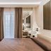 Resort Miramonti in Forte dei Marmi bedroom with balcony doors, desk, chair and mirrored wardrobe
