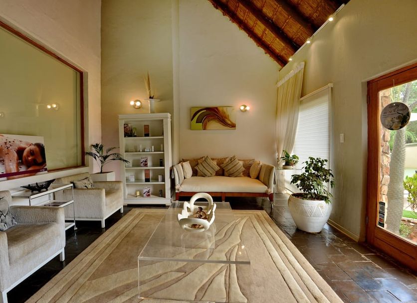 Kwafubesi Tented Safari Camp lounge in Rooiberg with seating, rug, high thatched ceiling and garden view