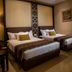 The Arnawa Hotel in Pangandaran: twin-bedded guest room with bedside lamp and wall art