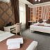 Kausar Hotel in Bishkek room with two beds, desk, patterned wallpaper and wall-mounted air conditioner