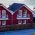 Nürburgring Ferienpark in Nuerburg, red chalet-style vacation homes with balconies by a lakeside