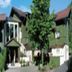 Landhotel Christopherhof in Grafenwiesen, exterior view of the hotel with trees and pitched roofs