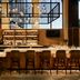 Bar and lounge at The Casso, Raleigh, a Tribute Portfolio Hotel in Raleigh with high stools and pendant lights