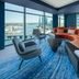 W Sydney lounge with curved orange sofa, city skyline and harbor views through floor-to-ceiling windows