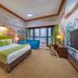 New Century Grand Hotel Kaifeng colorful family room with bed, sofa, and city-view balcony