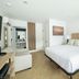 The Waypoint Rehoboth Beach guest room with king bed, sofa, and bathroom vanity