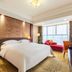 Tianheng International Hotel Jinhua guest room with king bed, red sofa, and city view window