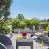 Living Hotel am Olympiapark Munich terrace with lounge chairs, table, and lush greenery