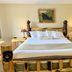 Beartooth Hideaway Inn & Cabins in Red Lodge, rustic log-framed bed with bear carved posts