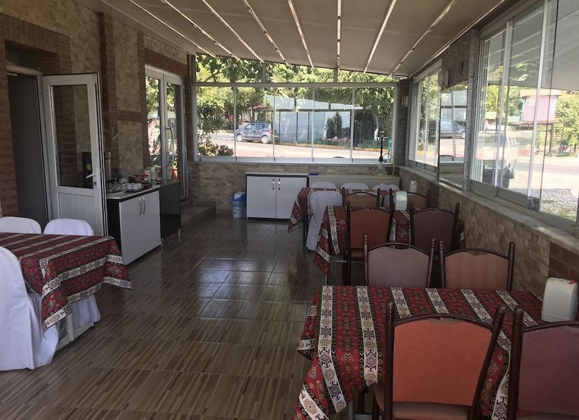 Anatolia Hotel Pamukkale dining area with tables and chairs beside large windows