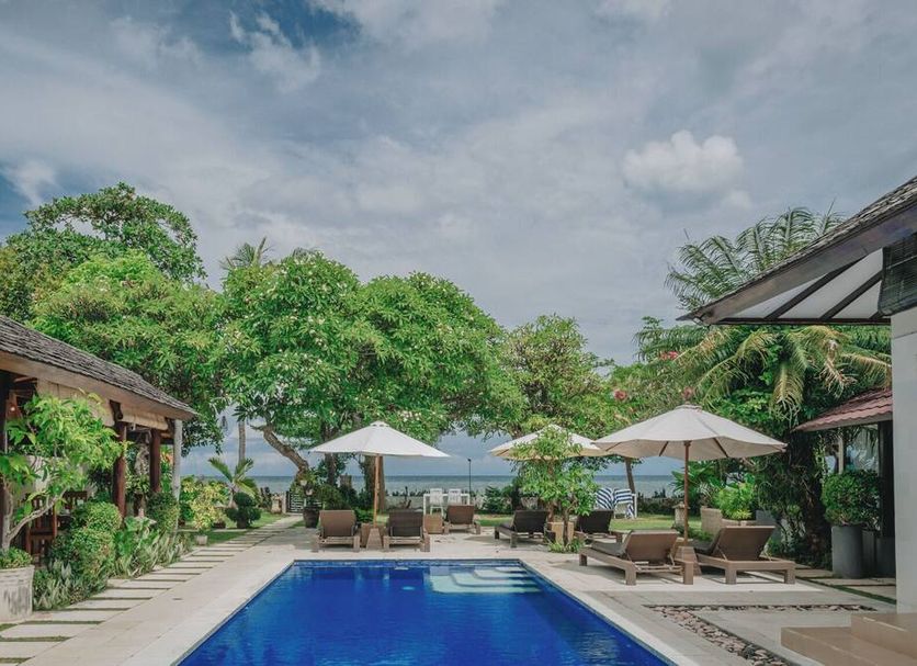 Frangipani Beach Hotel in Buleleng with ocean-view pool, loungers and umbrellas