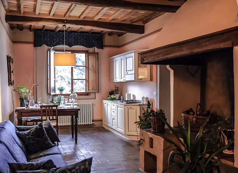 Locanda Il Pino in San Gimignano: cozy guest room with sofa, dining table, kitchenette, and fireplace
