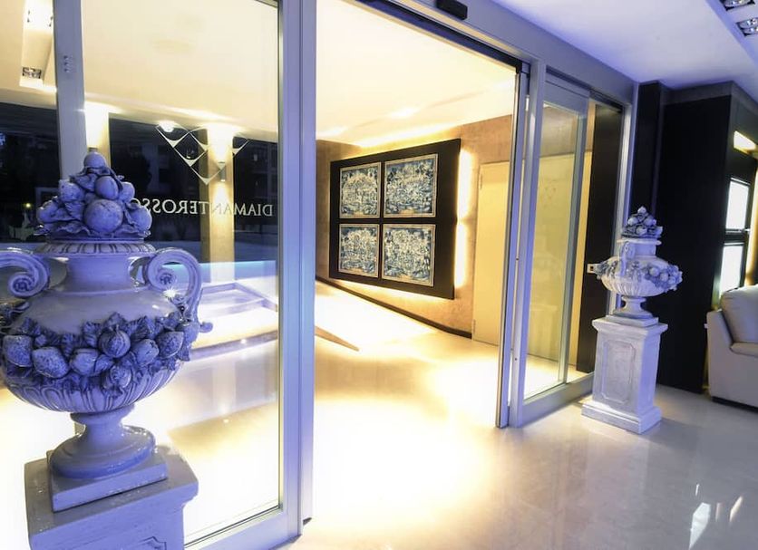Residence Diamanterosso in Terni with ornate urn sculptures beside a modern glass-walled interior