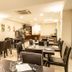 Hotel Premiere in Giugliano in Campania dining room with dark tables and chairs and set place settings