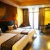 Yushuigu Hot Spring Hotel in Maoming guest room with two beds, desk, TV and balcony doors