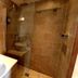 A Room With A View Brighton bathroom with glass shower, vessel sink and tan tile walls