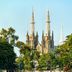 Pinx's Hostel in Jakarta with a cathedral-like landmark framed by lush green trees and blue sky