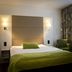 Sturup Airport Hotel in Sturup room with bed, green throw and armchair