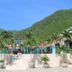 Hotel Kaamú Taganga exterior with palm trees, terrace, and green mountain backdrop
