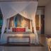 The Beach Tulum Hotel in Tulum: canopy bed with sheer drapes and colorful pillows in a stylish guest room