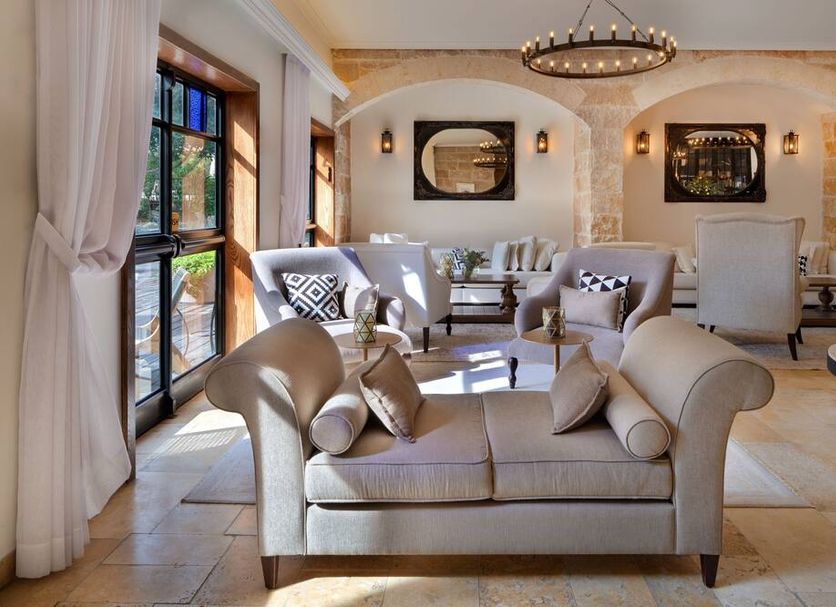 Herbert Samuel Bayit Bagalil Boutique in Rosh Pina lobby seating area with sofas, chairs and arched stone walls