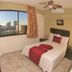 Hotel Playa Bonita in Mazatlán guest room with city view, bed, wall-mounted TV and ceiling fan
