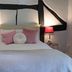 The Old Vicarage Hotel & Restaurant in Bridgwater bedroom with bed, pink cushions and bedside lamps