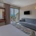 Rosy Suites Hotel in Kusadasi room with sofa, balcony sea view, and wall-mounted TV