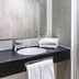 B&B Hotel München-Trudering bathroom with sink, mirror, towels, and glass shower in Munich