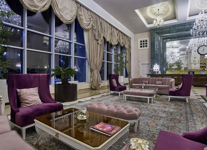 Rixos President Astana lobby with purple velvet chairs, glass tables, ornate chandelier and tall windows