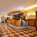 Ca Rialto House Venice lobby with wood reception desk, checkered tile floor and green leather sofa