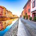 B&B I 10 Mondi in Milan with colorful canal-side buildings and waterside walkway