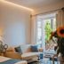 Médousa Suites in Taormina guest room with sofa, patterned floor, and balcony doors to greenery