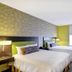 Home2 Suites by Hilton Idaho Falls guest room with two beds, desk, and window light