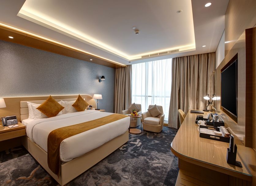 The S Hotel Al Barsha in Dubai guest room with king bed, seating area, and large window