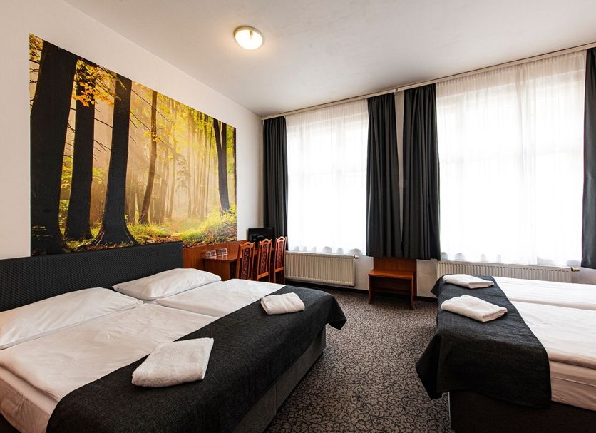 Hotel Zlatá Váha Prague guest room with twin beds, forest wall art, and large windows