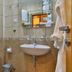 Hotel Stella di Mare in Bečići bathroom with shower, wall-mounted sink, toilet, and tiled walls