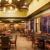 The Q Hotel & Suites in Springfield lobby lounge with tables, chairs, fireplace and large windows