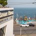 Jeju Oda Pension in Jeju City with ocean view, seaside pool, and parked cars