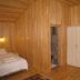 Cirali Almira Bungalow in Cirali room with wood-paneled walls, two beds, wardrobe and air conditioner