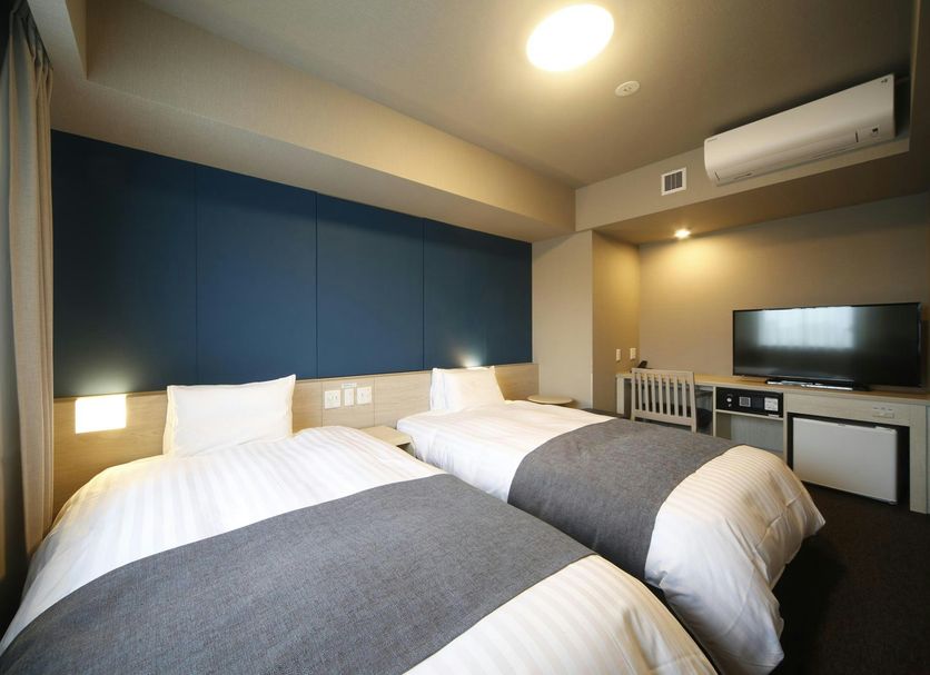 Dormy Inn Miyazaki Natural Hot Spring guest room with two twin beds and TV