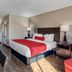 SureStay by Best Western Greenville guest room with king bed, nightstands, armchairs and hardwood floor