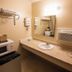 Northwinds Motel in Mackinaw City guest sink area with microwave, mini fridge, coffee maker, and wall AC