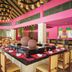 Hideaway at Royalton Punta Cana dining room with pink walls, high ceiling, and central buffet display