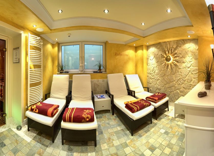 Nordwest-Hotel Bad Zwischenahn spa relaxation room with loungers and sauna door in Bad Zwischenahn