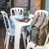 Hotel Snö Condes del Pallars in Rialp: balcony table with white chairs and a backpack