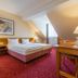 Galerie Hotel Leipziger Hof in Leipzig: cozy twin-bed guest room with desk, lamps and sloped ceiling