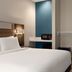Holiday Inn Express & Suites Edmond guest room with king bed, desk nook and blue accent wall