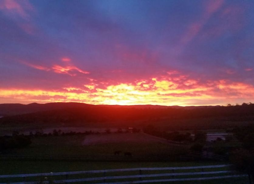 Sunset view over hills and water from Cornwall Cottage in Hobart