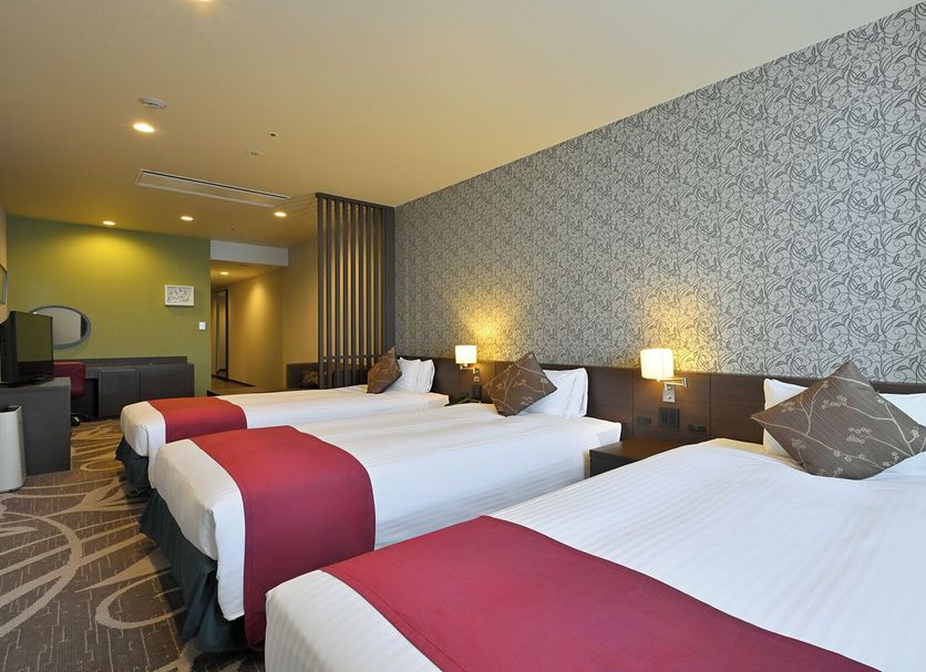 Quintessa Hotel Osaka Bay guest room with three twin beds and patterned wallpaper in Osaka